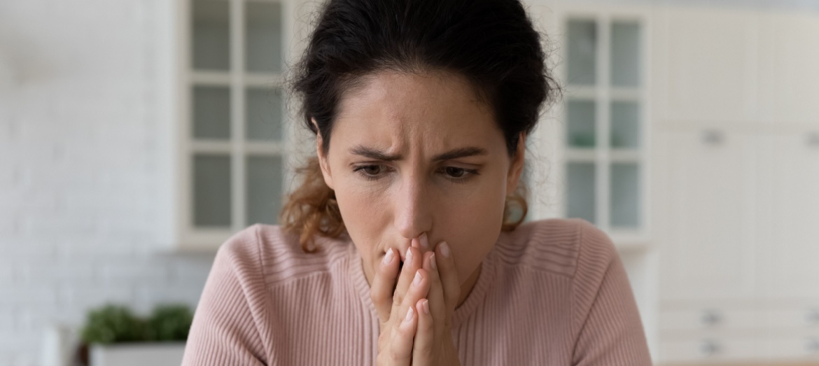 A woman looks at her laptop in shock.