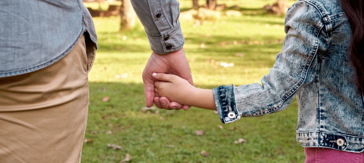 Parent and child holding hands.
