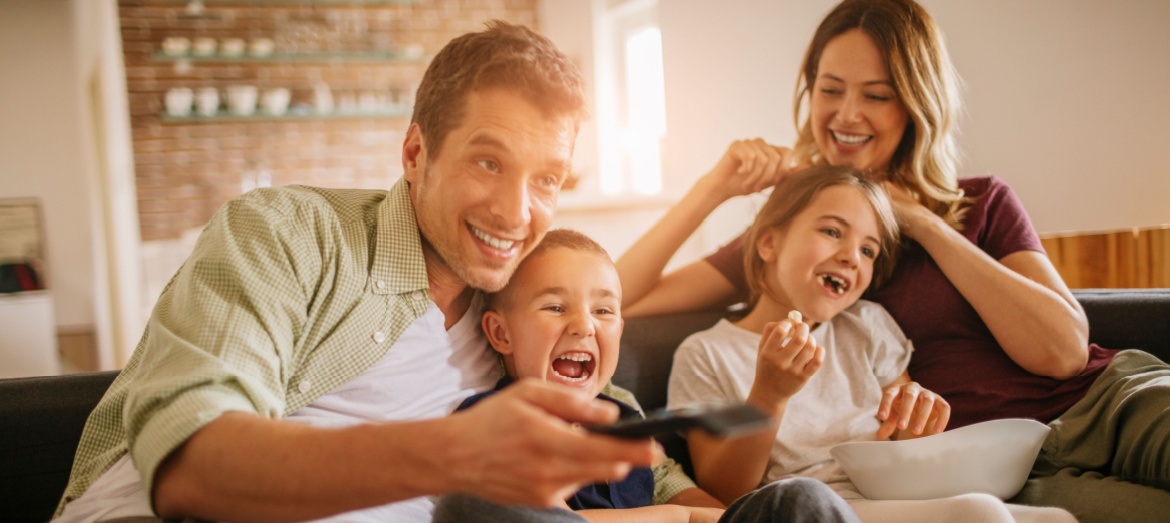 A young family watching TV together.
