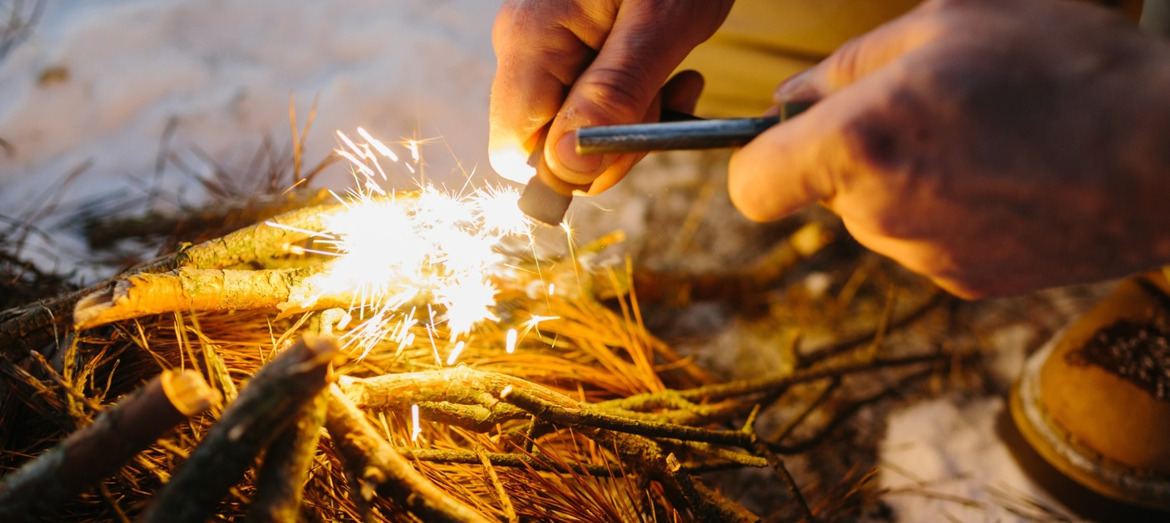 A close-up of a man starting a fire.