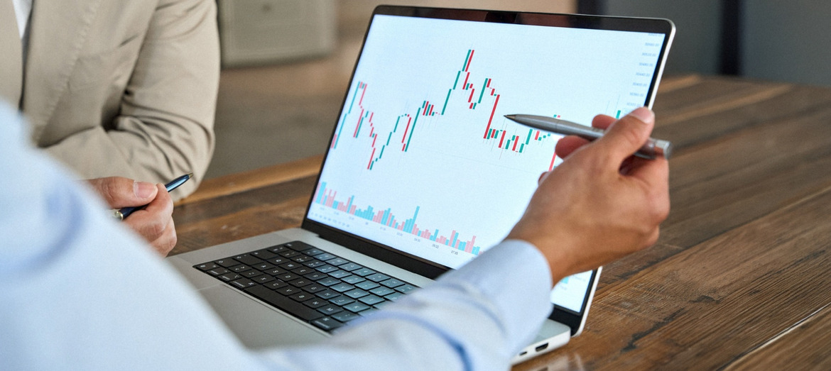 A man reviewing stock market movements on a laptop.