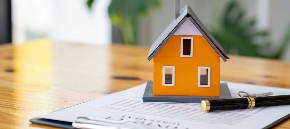 A model of a house sitting on some paperwork.